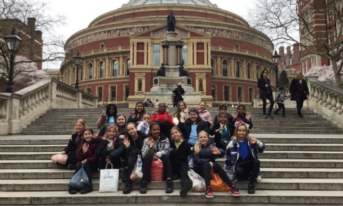 Group photo of the school choir sat on the steps outside The Royal Albert Hall